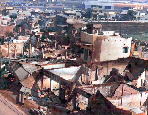 Mehrere Gebäude, einige davon eingestürzt, sind auf dem Bild zu sehen.