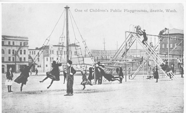 Eine Gruppe von Kindern spielt auf einer Schaukelanlage in einem öffentlichen Spielplatz in Seattle, Washington, mit Leitern und Pfählen im Vordergrund, Gebäuden und einem klaren Himmel im Hintergrund und Text oben und unten auf dem Schwarz-Weiß-Bild.