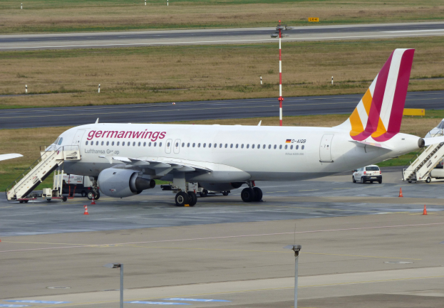 Ein Airbus A320-200 der Germanwings auf dem Frankfurter Flughafen geparkt, mit Fahrzeugen, Verkehrskegeln, Pfählen und Gras im Hintergrund.