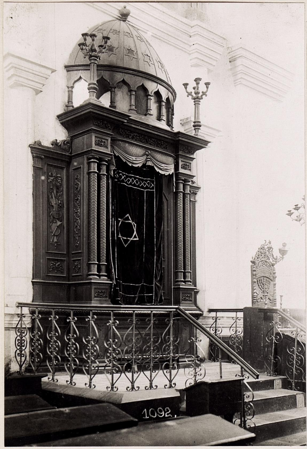 Schwarzes und weißes Foto einer jüdischen Synagoge in New York City mit Treppe, Geländer, Säulen, Tür und Wand.