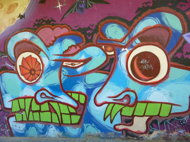 Ein farbenfrohes, buntes Wandgemälde mit Graffiti-Kunst an der Seite eines Gebäudes