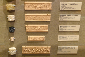 Vitrine voller verschiedener altertümlicher Artefakte, darunter Schnitzereien und Texte auf Tafeln, ordentlich und sauber angeordnet.