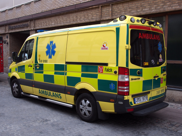 Ambulanz vor einem Backsteinbau geparkt mit Text, daneben ein Feuerlöscher.