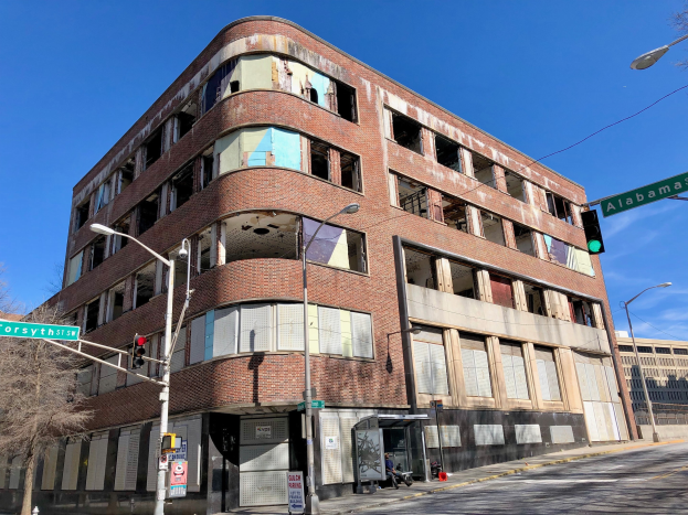 Altes Backsteingebäude an einer Straßenecke, ehemaliger Hauptsitz der University of Illinois at Chicago, mit umgebender Straßeninfrastruktur und Fahrzeugen.
