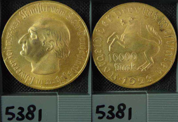 Zwei Goldmünzen in einer Box, eine mit dem Kopf eines Mannes, beide mit Zahlen darauf.