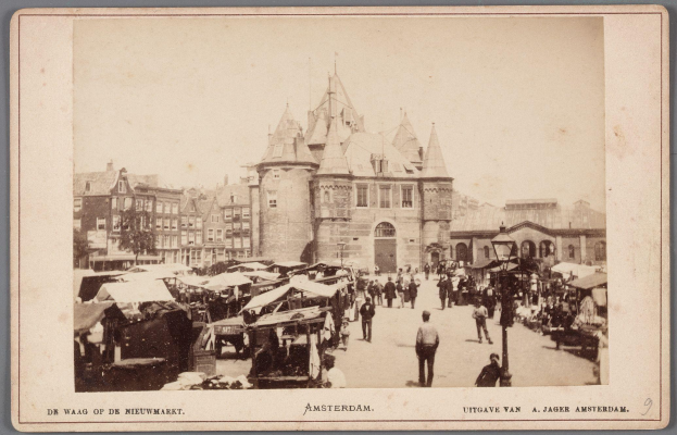 Schwarz-weiß-Foto eines belebten Amsterdamer Marktes mit Passanten, Verkaufsständen und Gebäuden im Hintergrund, mit Text unten.