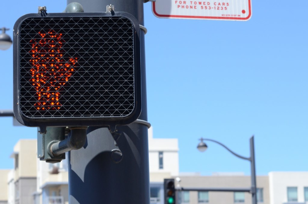 Eine Straßenszene mit Verkehrspfählen, Ampeln, Straßenlaternen, Gebäuden und Himmel.