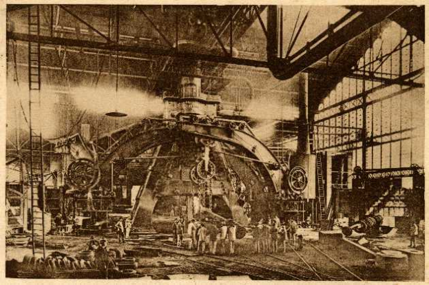 Ein Schwarz-Weiß-Foto einer Fabrikszene in der Cadillac Steel Works, das Menschen bei der Bedienung einer großen Maschine zeigt, umgeben von Leitern, Stangen und anderem Equipment.