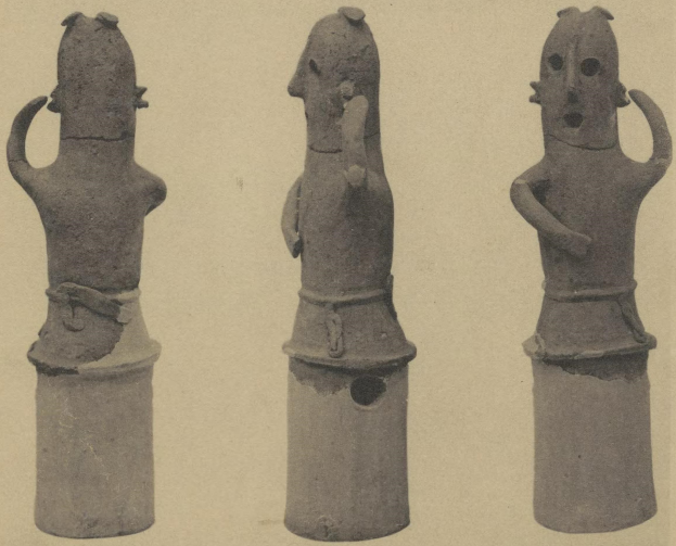 Drei Terrakottastatuen eines Mannes und einer Frau in traditioneller Kleidung, die eng beieinanderstehen und der Mann seinen Arm um die Schulter der Frau legt.