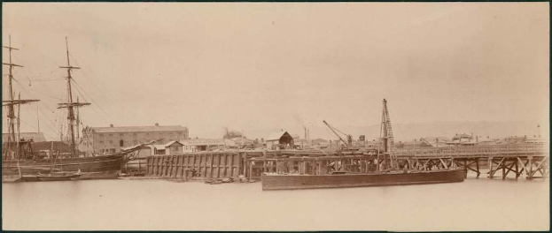 Eine Szene mit Wasser, Booten, Geb├Ąuden, Strommasten, Himmel.