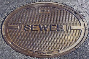 Metall-Schachtobjekt auf der Straße mit der eingravierten Aufschrift "Kanal"