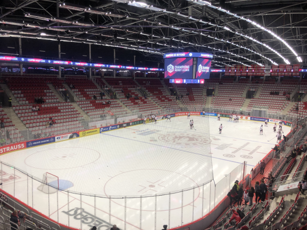 Eishockeyspiel in einer großen Arena zwischen den St. Louis Blues und Detroit Red Wings, mit Zuschauern auf den Sitzen und am Rand der Eisbahn.
