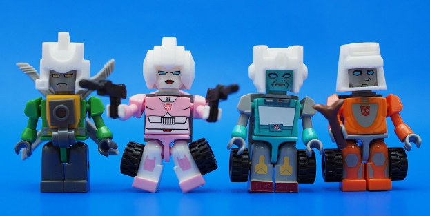 Vier Roboter-Spielzeuge sind auf einer blauen Oberfläche plaziert.