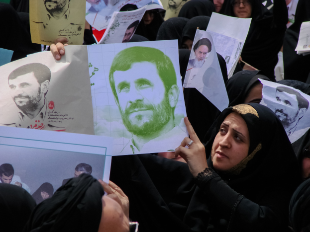 Eine Gruppe iranischer Frauen in schwarzer Kleidung, einige tragen Brillen, halten Fotos von Präsident Mahmoud Ahmadinejad während einer Demonstration in Tehran hoch.