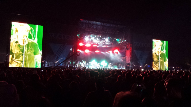 Ein Konzertbild mit einer Menge unten, einem großen Bildschirm links und einem kleineren rechts.