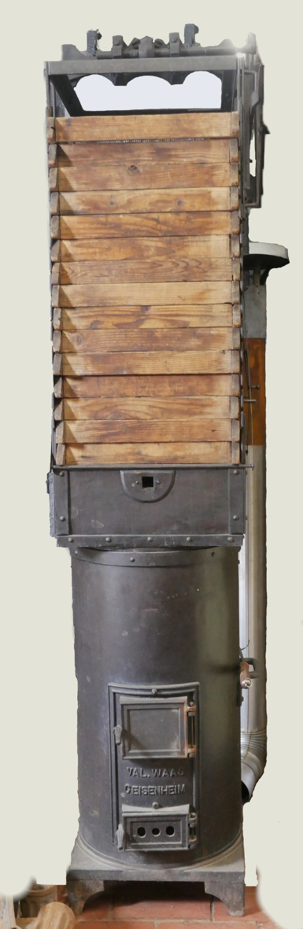 Altmodischer Holzofen mit Metall- und Holzkonstruktion, Schornstein und Ziegelboden.