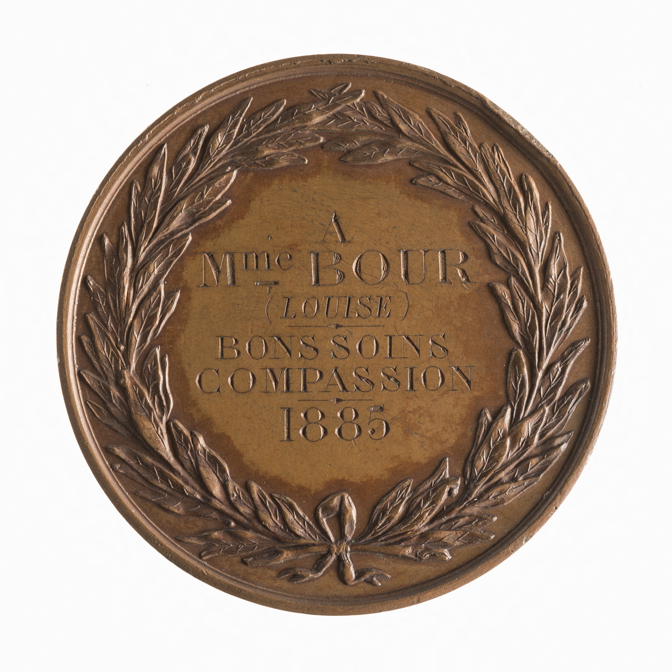 Bronze-Medaille mit Lorbeerkranz-Design und der Beschriftung "Bons Soins Compassion" auf wei├čem Hintergrund.